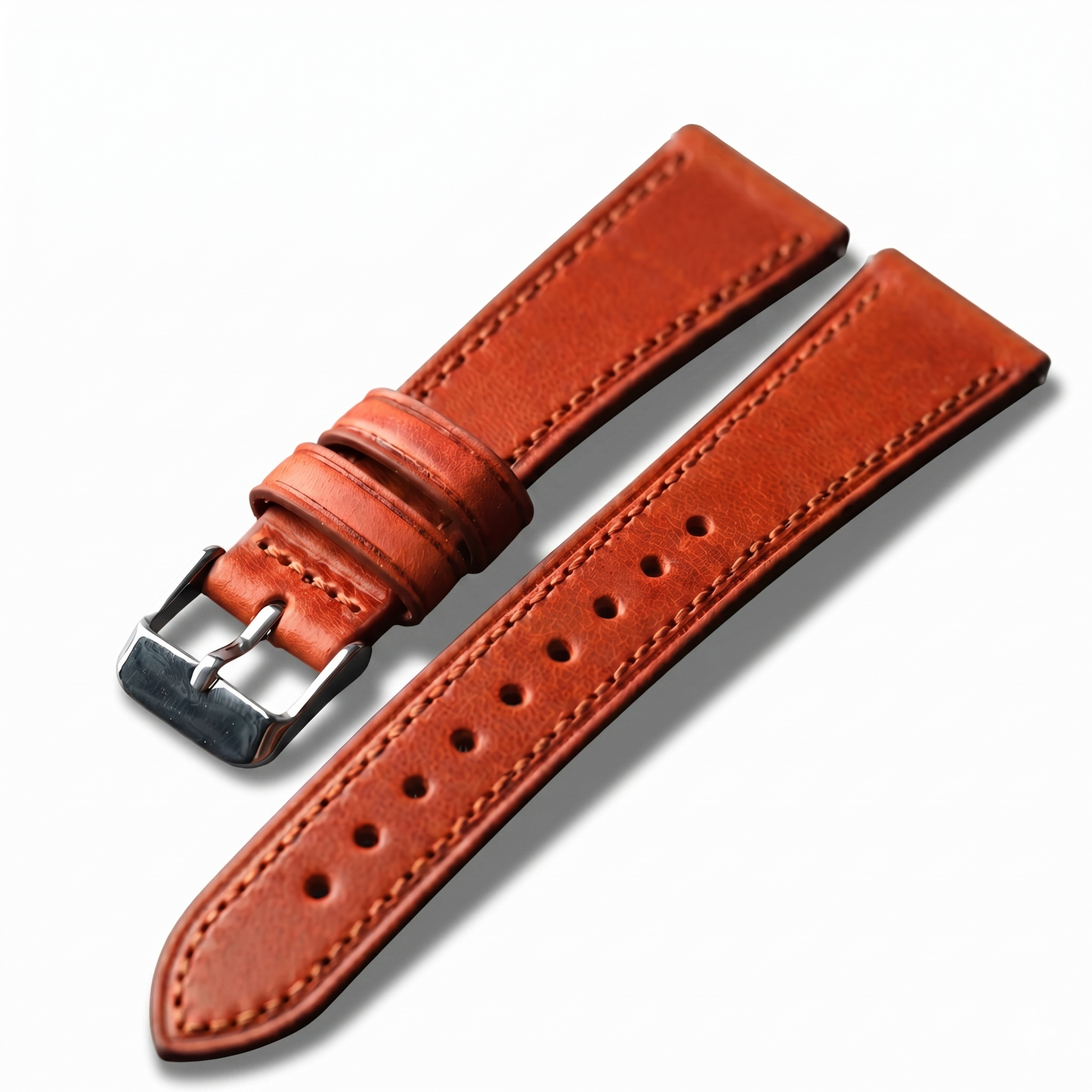 Brown leather watch strap with silver buckle on a white background