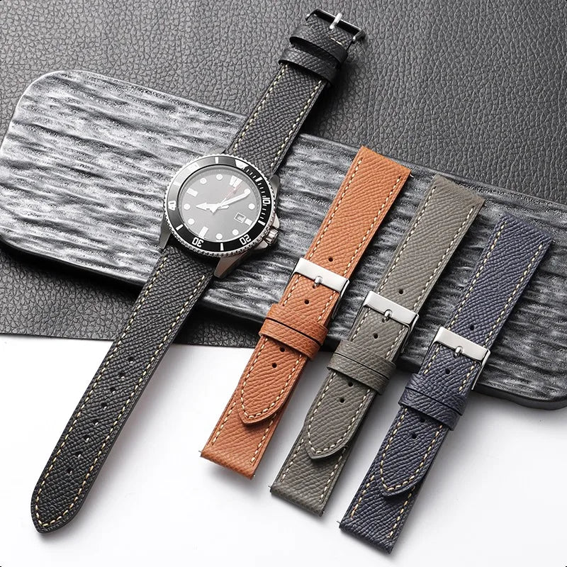 Set of leather watch straps in various colors on a wooden surface