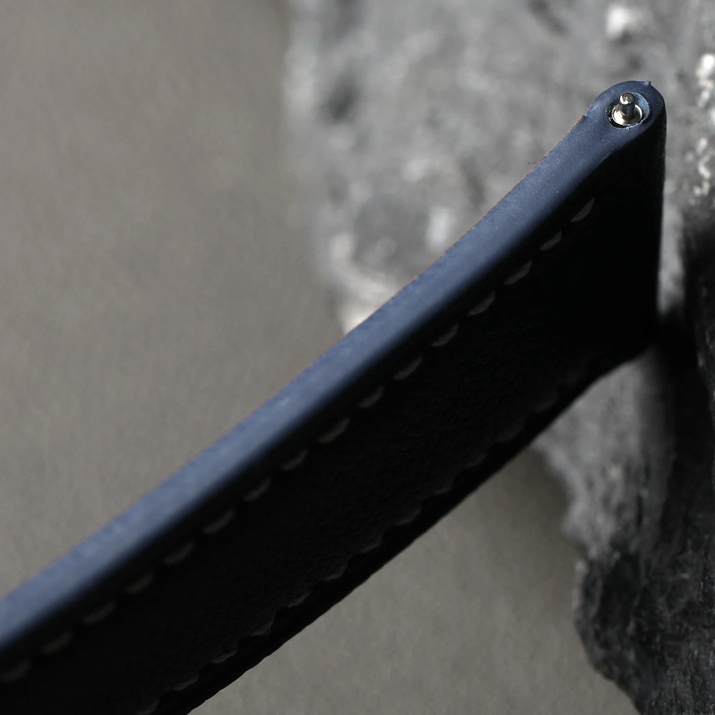 Close-up of a black metal bracket against a textured gray background