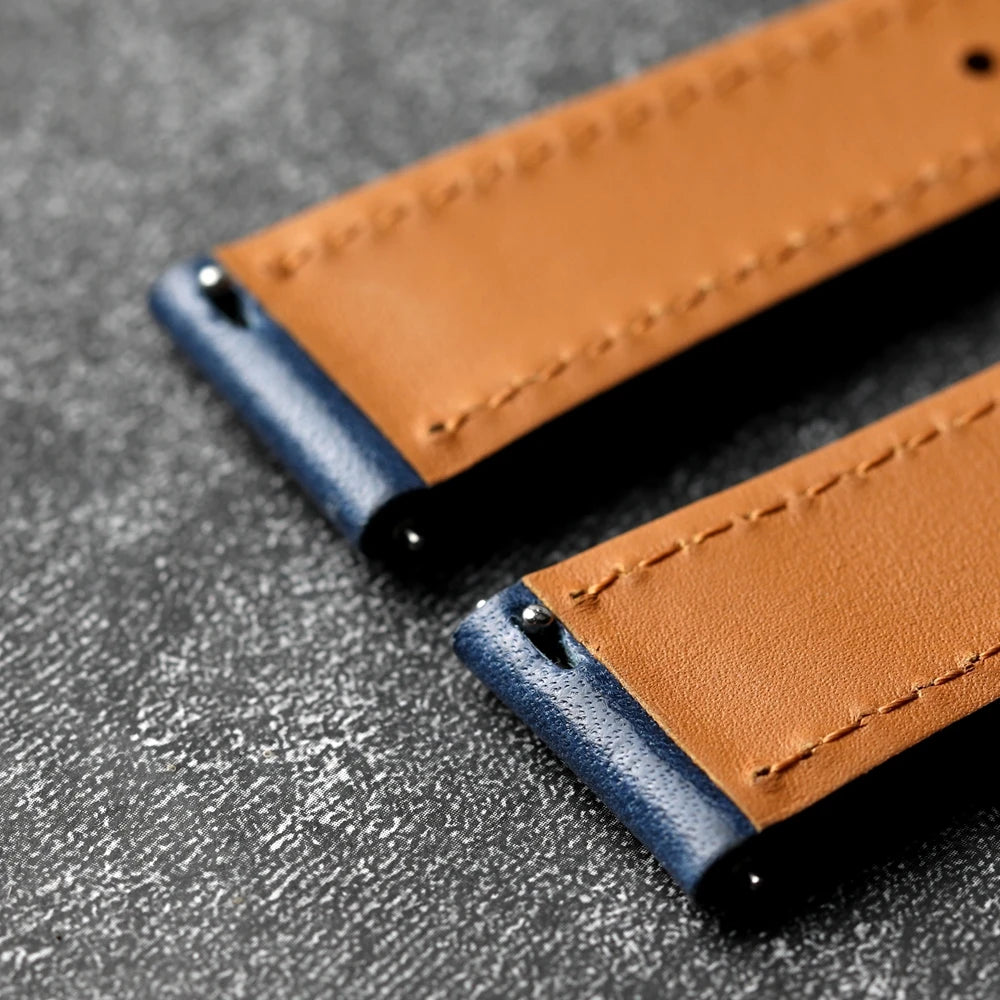 Close-up of a brown and blue leather strap on a gray surface