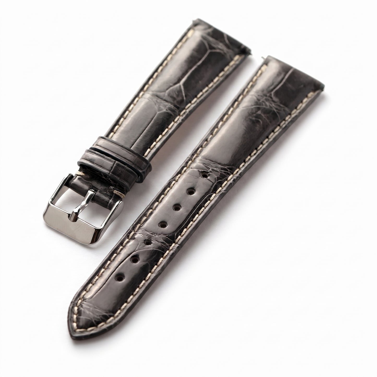 A dark gray alligator leather watch strap with light beige contrast stitching and a polished silver-tone buckle, displayed on a clean white background.