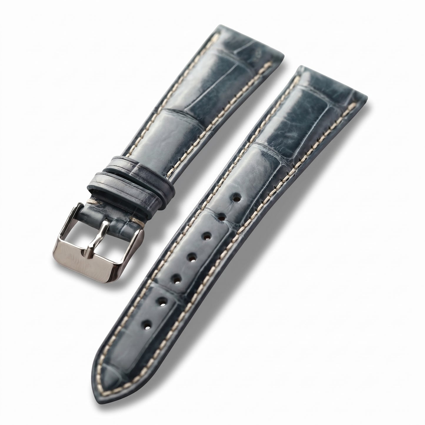A dark blue-gray leather watch strap with light beige contrast stitching and a silver-tone metal buckle, displayed on a clean white background.