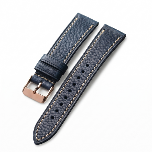 Blue leather watch strap with rose gold buckle on a white background