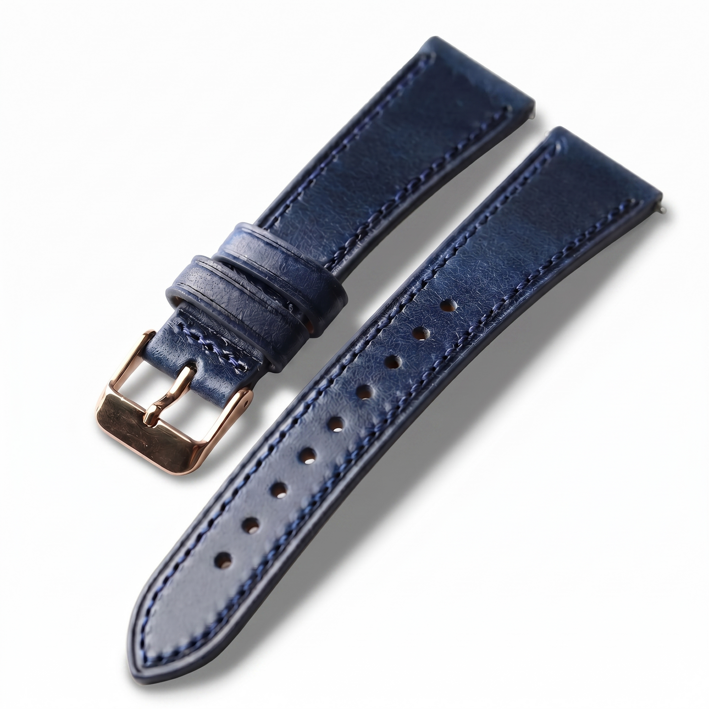 Blue leather watch strap with rose gold buckle on a white background