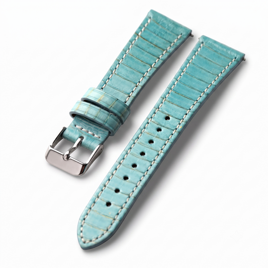 A light turquoise leather watch strap with a textured crocodile pattern, white contrast stitching, and a silver-tone buckle, shown on a clean white background.