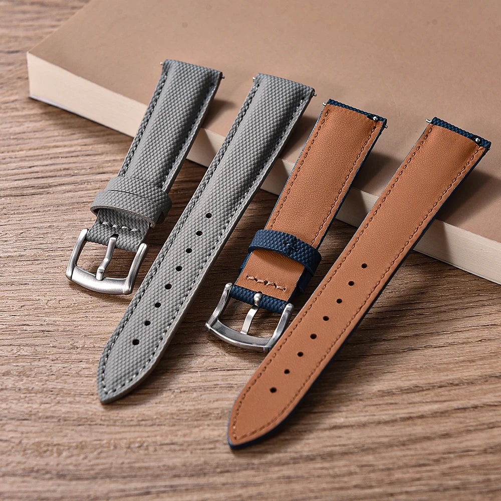 Three watch straps in gray, brown, and blue on a wooden surface.