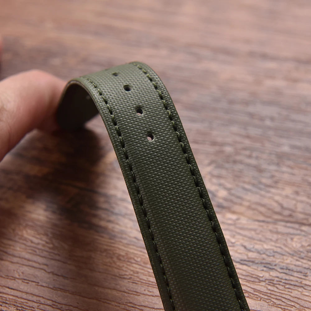 Green belt strap held by a hand on a wooden surface