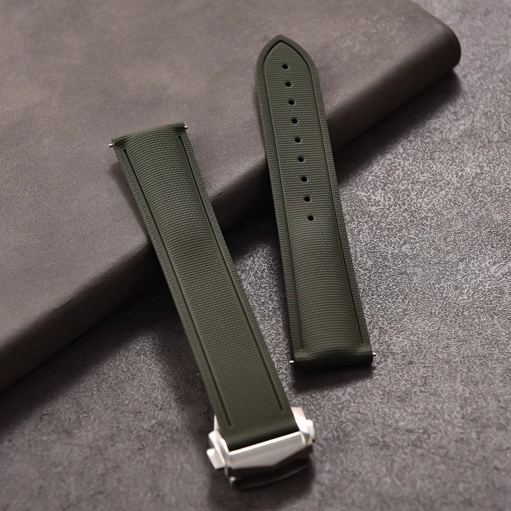 Green watch strap with silver clasp on a gray surface