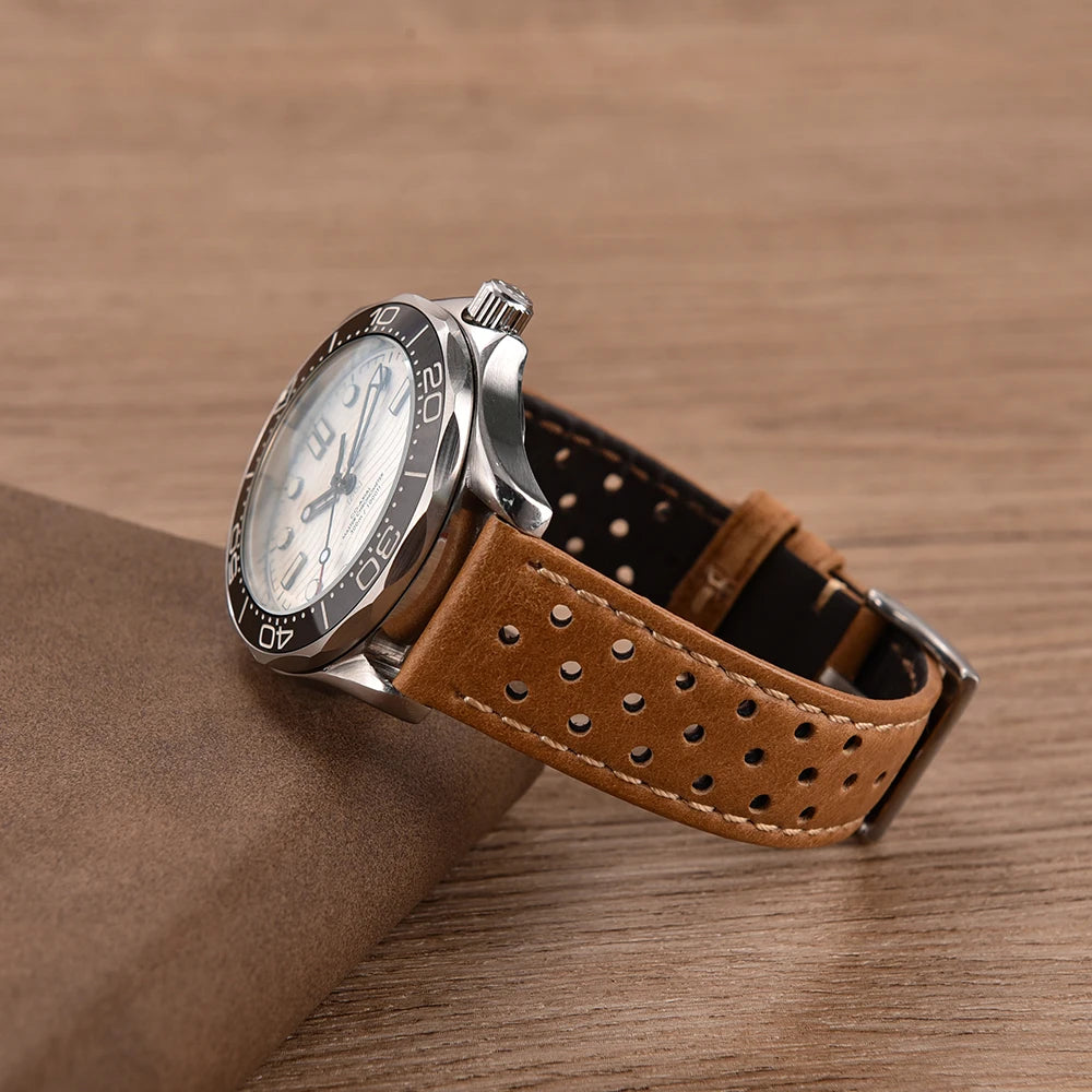Wristwatch with brown perforated leather strap on a wooden surface